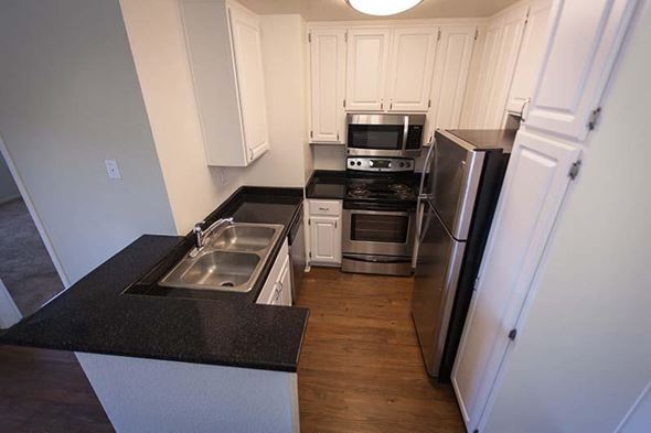 Salinas apartment for rent - a kitchen with stainless steel appliances and black counter tops