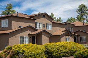 Flagstaff apartment for rent - a large brown house with bushes in front of it