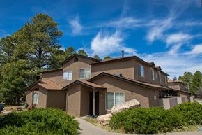 Flagstaff apartment for rent - a brown house with trees and a blue sky
