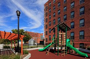 Troy apartment for rent - a playground with a large brick building and
