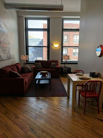 Troy apartment for rent - a living room with couches and a table and two windows