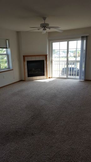 Sun Prairie apartment for rent - an empty living room with a fireplace and a ceiling fan