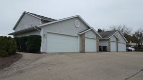 Sun Prairie apartment for rent - a white house with two garage doors and a driveway