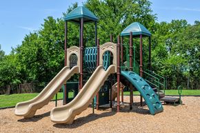 Chattanooga apartment for rent - a playground with two slides and trees in the background
