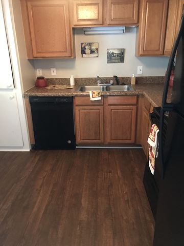 Birmingham apartment for rent - A kitchen with wooden cabinets and a black refrigerator.