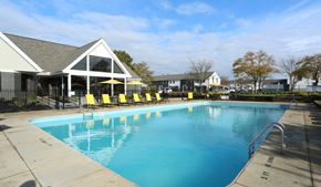 Westerville townhouse for rent - a swimming pool with yellow chairs in front of a house