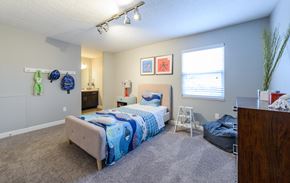 Westerville townhouse for rent - a bedroom with a bed and a dresser and a window