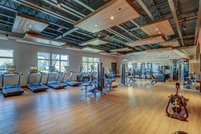 Middleton apartment for rent - a gym with cardio machines and weights on a wooden floor