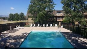 Arvada apartment for rent - a swimming pool with chairs in front of a house