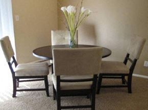 Arvada apartment for rent - a dining room table with chairs and a vase with flowers