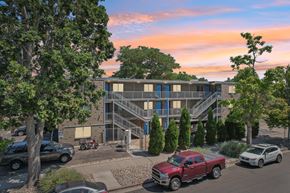 Denver apartment for rent - A red pickup truck is parked in front of a building with a parking lot.