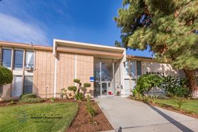 Gardena apartment for rent - a building with a sidewalk and a tree in front of it