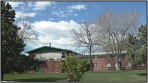 Arvada apartment for rent - a red brick house with a green roof and a lawn