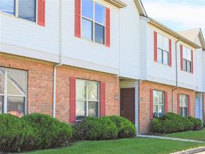 Grove City apartment for rent - A white building with red trim and windows.