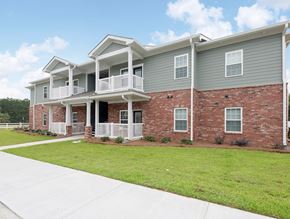 Nashville apartment for rent - an exterior view of an apartment building with green grass and a sidewalk