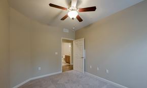 Nashville apartment for rent - a bedroom with a ceiling fan and a door to a bathroom