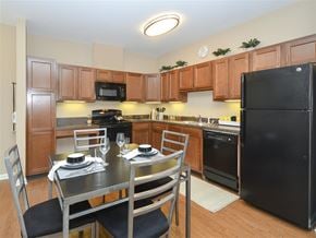 Cleveland apartment for rent - A kitchen with a black refrigerator and wooden cabinets.