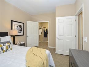 Cleveland apartment for rent - A bedroom with a bed, a lamp, a painting, a wardrobe and a table.
