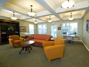 Wauchula apartment for rent - Comfortable community lounge with sofa seating, armchairs, and round tables, complemented by large windows and decorative ceiling lighting.