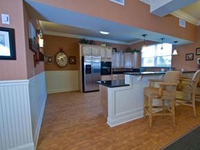 Wauchula apartment for rent - Open kitchen with wood-style flooring, light cabinetry, large island with seating, and stainless steel appliances in a bright, inviting layout.