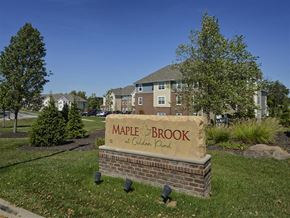 Kent apartment for rent - A sign for Maple Brook at Golden Plain in front of a building and trees.