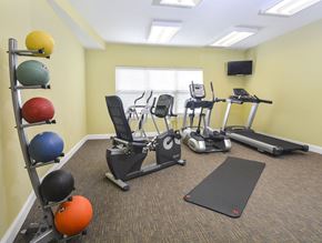 Columbus apartment for rent - A gym room with a variety of equipment including treadmills, stationary bikes, and exercise balls.