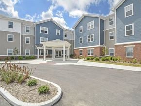 Findlay apartment for rent - A large building with a grey and blue exterior and a white entrance.