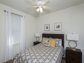 Balcones Heights apartment for rent - A bedroom with a bed, two nightstands, and a ceiling fan.
