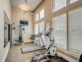 Balcones Heights apartment for rent - A well-equipped home gym with a treadmill, elliptical trainer, and a television.