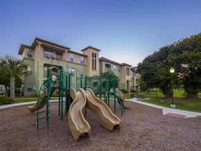 Corpus Christi apartment for rent - A playground with a green slide and a red and white striped area on the ground.