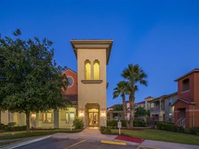 Corpus Christi apartment for rent - A building with a tower and arched windows is lit up at dusk.