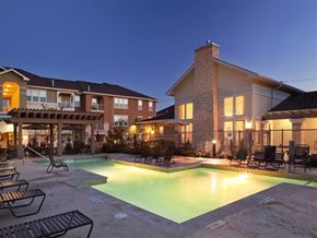 San Marcos apartment for rent - Swimming pool with surrounding lounge chairs, shaded pergola seating, and adjacent clubhouse, providing residents with an outdoor space for relaxation and recreation.