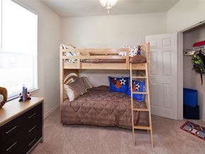 San Marcos apartment for rent - Secondary bedroom with bunk beds, soft carpeting, a large window providing natural light, and a spacious closet.