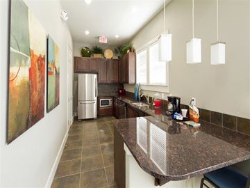 San Marcos apartment for rent - A kitchen with a refrigerator, microwave, and a counter with a few items on it.
