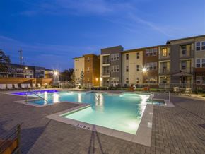 San Antonio apartment for rent - a swimming pool at night with an apartment building in the background