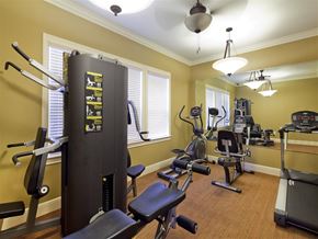 Houston apartment for rent - A home gym with a variety of equipment including a treadmill, weights, and a bench press.