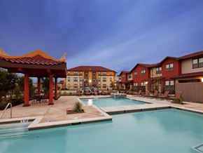 Houston apartment for rent - A pool area with a red pavilion and a building in the background.