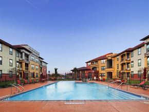 Houston apartment for rent - A swimming pool surrounded by apartment buildings.