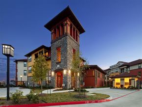 Houston apartment for rent - A building with a red and brown facade and a tower with a red roof.