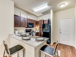San Antonio apartment for rent - A kitchen with a table set for two and a refrigerator.