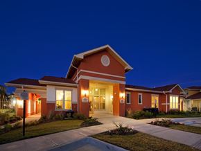 Laredo apartment for rent - A building with a red and white facade is illuminated by lights at night.