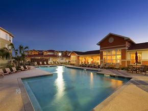 Laredo apartment for rent - A large swimming pool surrounded by lounge chairs and umbrellas at a resort.