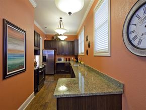 Laredo apartment for rent - A kitchen with a granite counter top and a large clock on the wall.