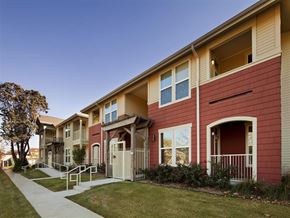 Fort Worth apartment for rent - A row of townhouses with a sidewalk in front.