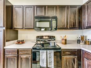 Dallas apartment for rent - A kitchen with a stove top oven and a microwave above it.