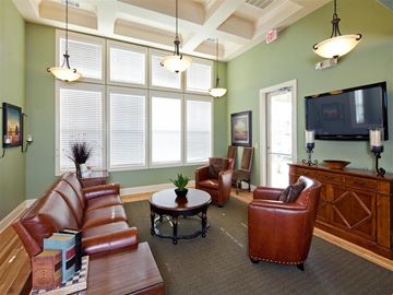 Karnes City apartment for rent - A living room with a brown leather couch and a wooden cabinet.