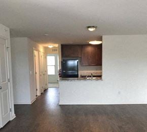 Flemington apartment for rent - an empty living room and kitchen with a black refrigerator