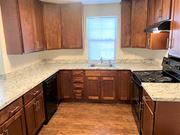 Flemington apartment for rent - an empty kitchen with wooden cabinets and granite counter tops