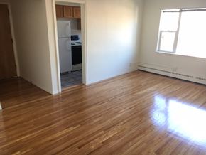 St Paul apartment for rent - an empty living room with wood floors and a kitchen