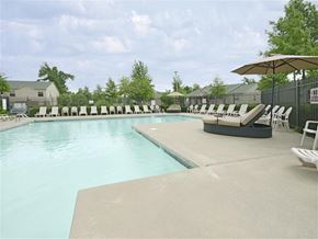 Fayetteville apartment for rent - a swimming pool with chairs and umbrellas next to it